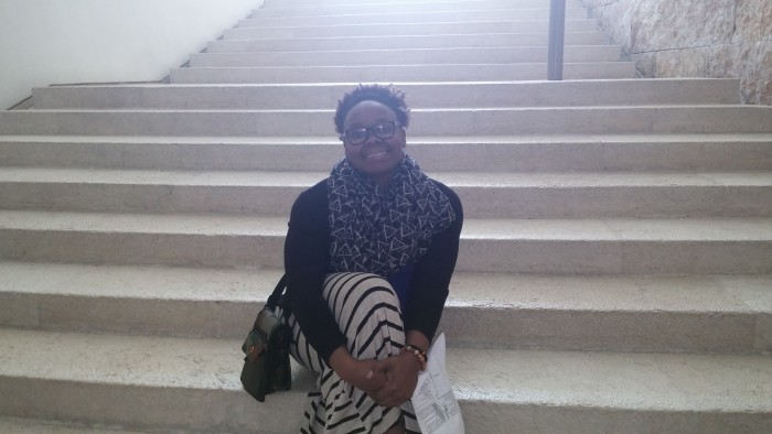 Chidi taking a seat on the steps of the Supreme Court of Israel. 