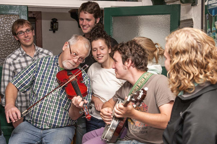 A group of people playing and listening to folk music.